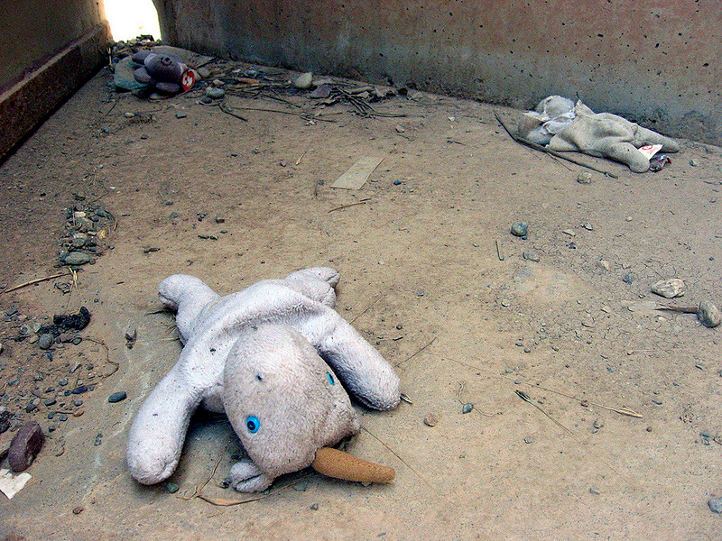 Children's plush toys abandoned in a war damaged building.