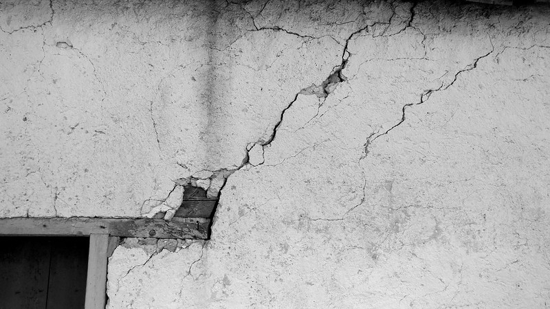 Crack in a wall, zigzagging upward from the corner of a doorway