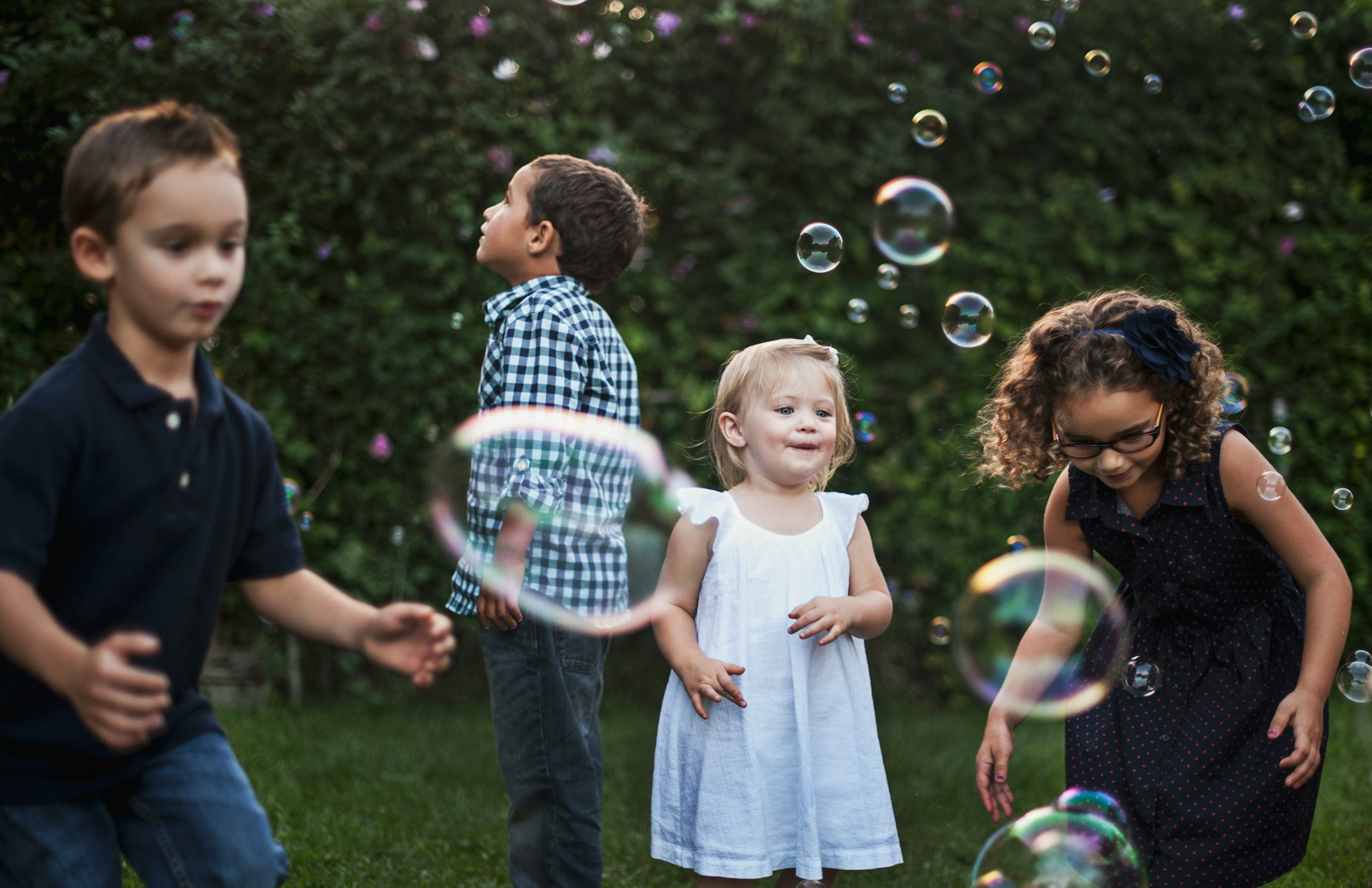 Children playing outside with bubbles